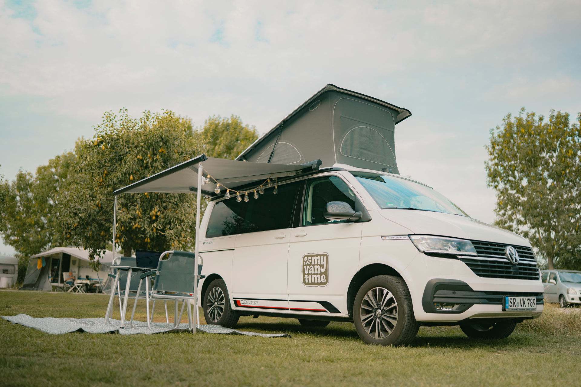 VW T6.1 California Beach mit aufgestelltem Dach und ausgefahrener Markise, zu mieten bei My Vantime in Aiterhofen bei Straubing